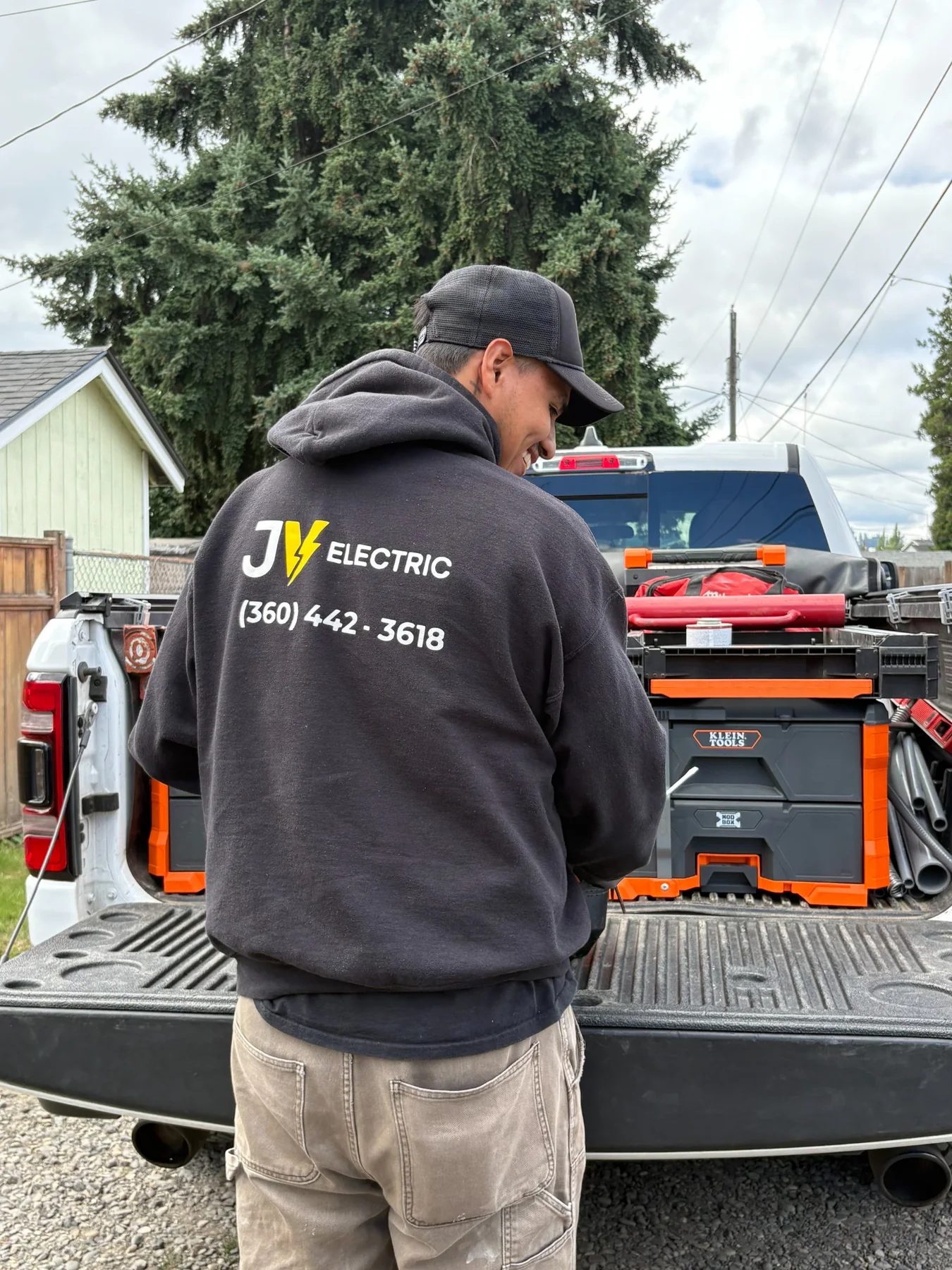 JV Electric electrician beside a fully stocked work truck